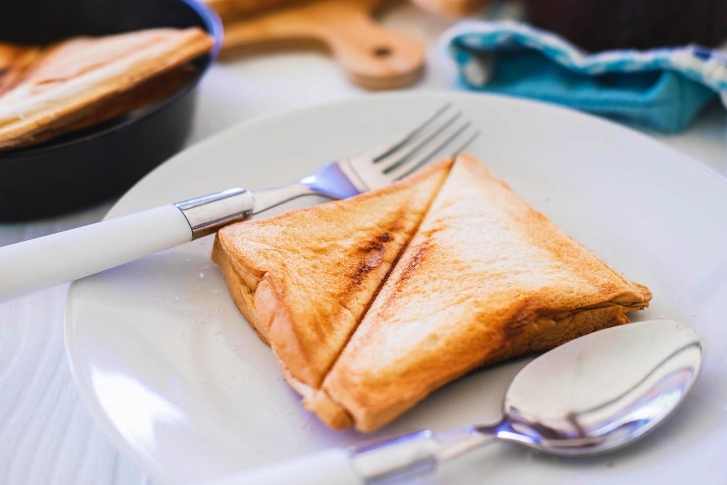 Roasted toast bread popping up of a stainless steel toaster in a home kitchen. photo