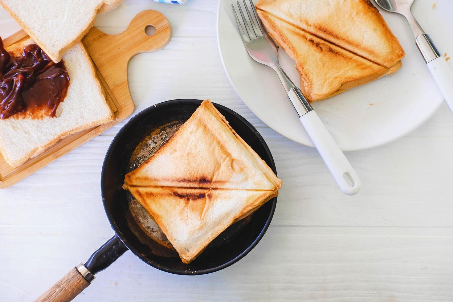 Roasted toast bread popping up of a stainless steel toaster in a home kitchen. photo