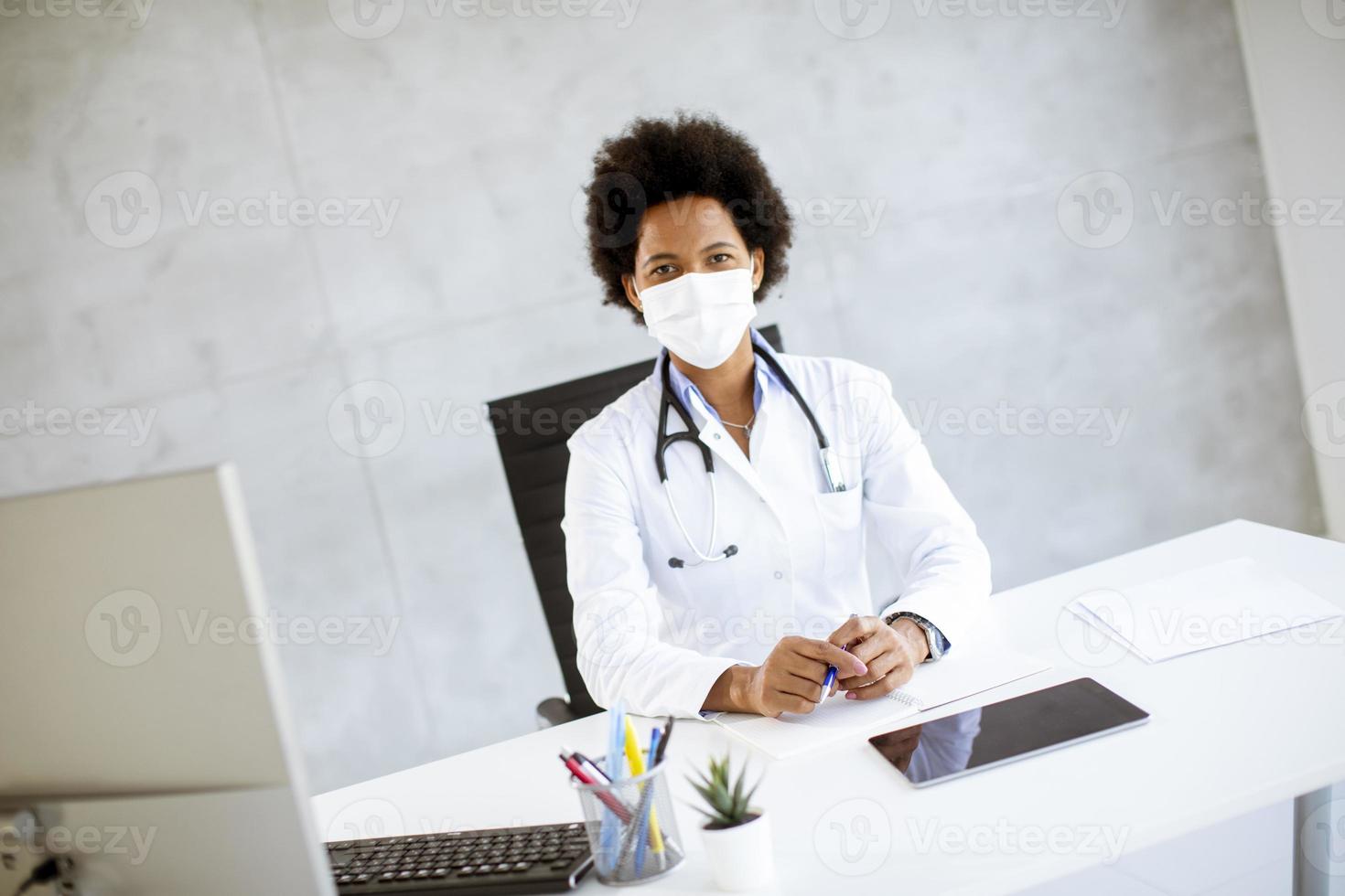 Doctor working at a desk with mask on photo