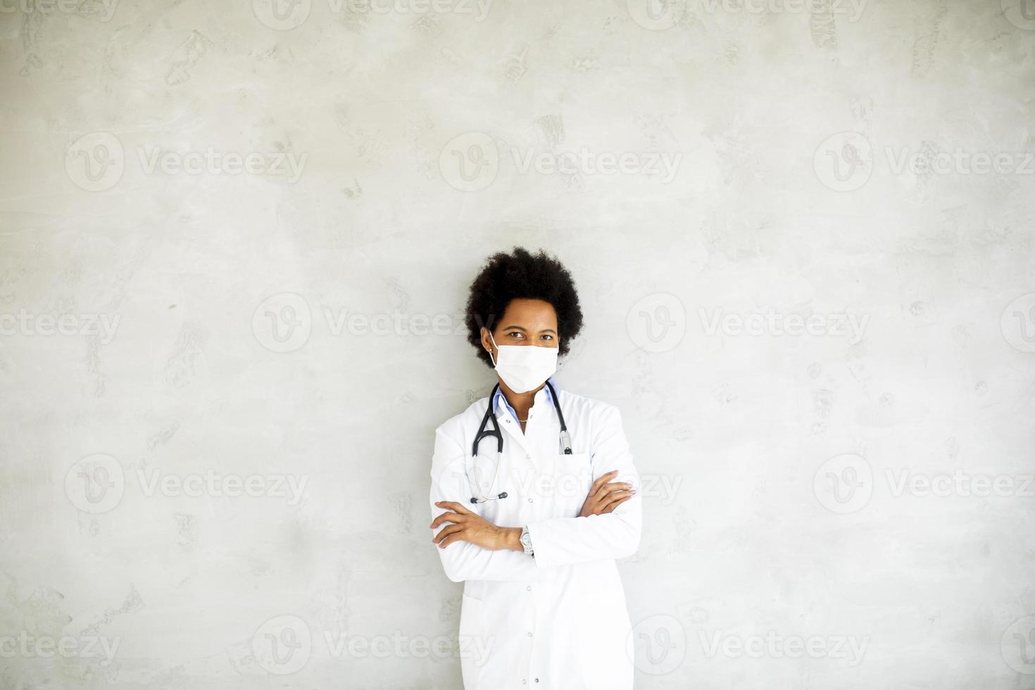 Masked doctor against a gray wall with copy space photo