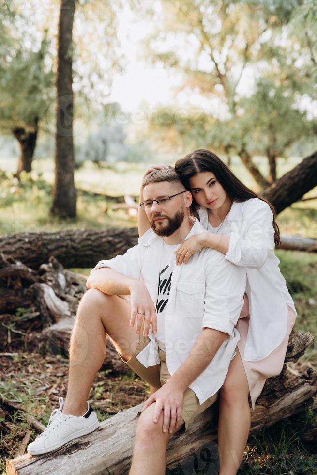 Pareja joven enamorada de un chico con barba y una chica de cabello oscuro con ropa clara foto