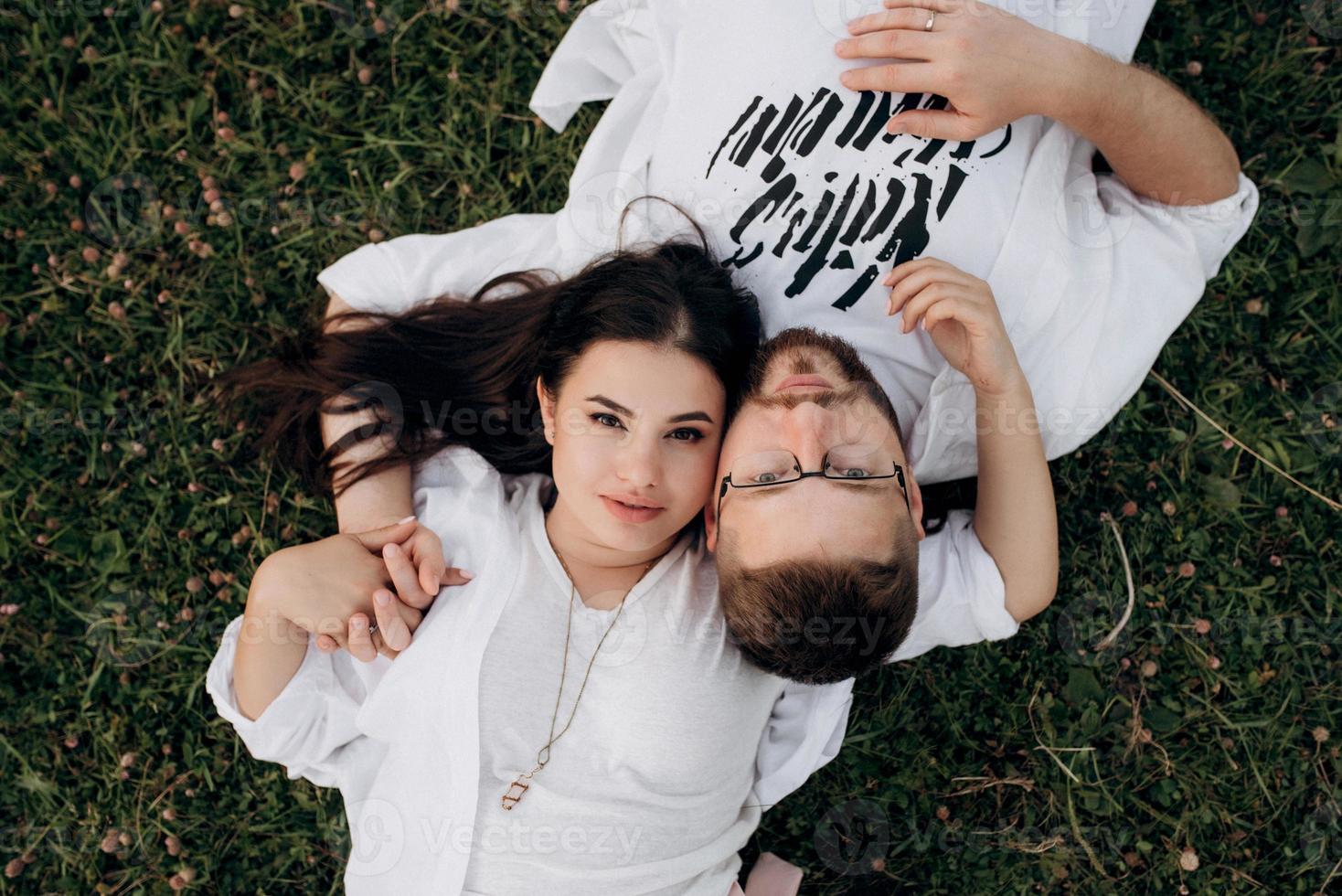 Pareja joven enamorada de un chico con barba y una chica de cabello oscuro con ropa clara foto