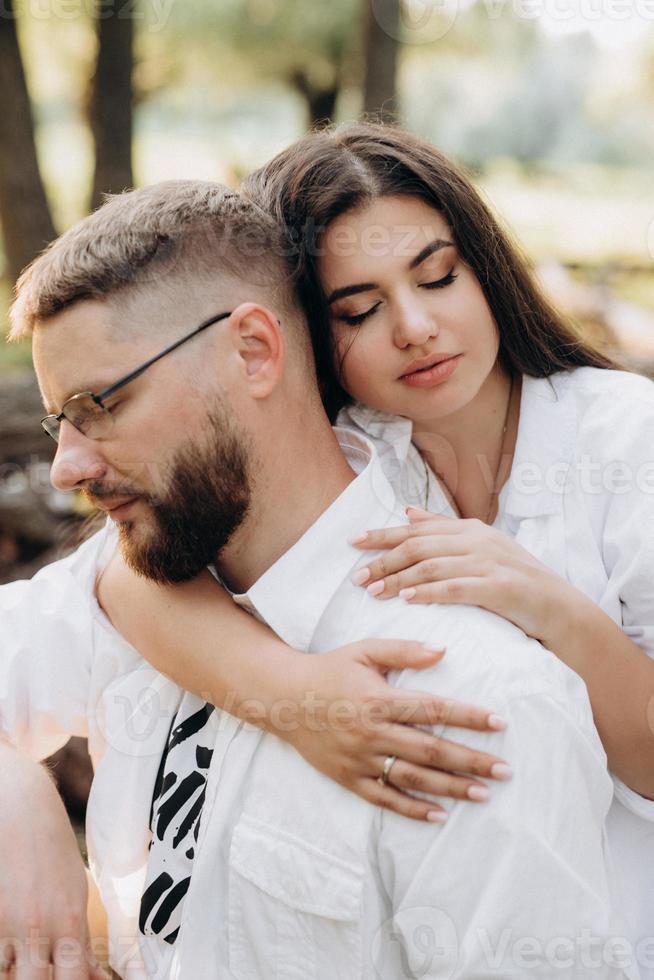 Pareja joven enamorada de un chico con barba y una chica de cabello oscuro con ropa clara foto