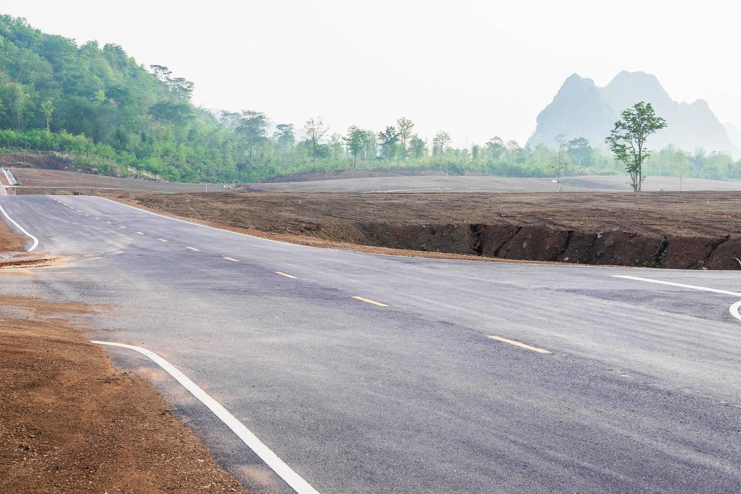 A long straight road leading towards a mountain photo