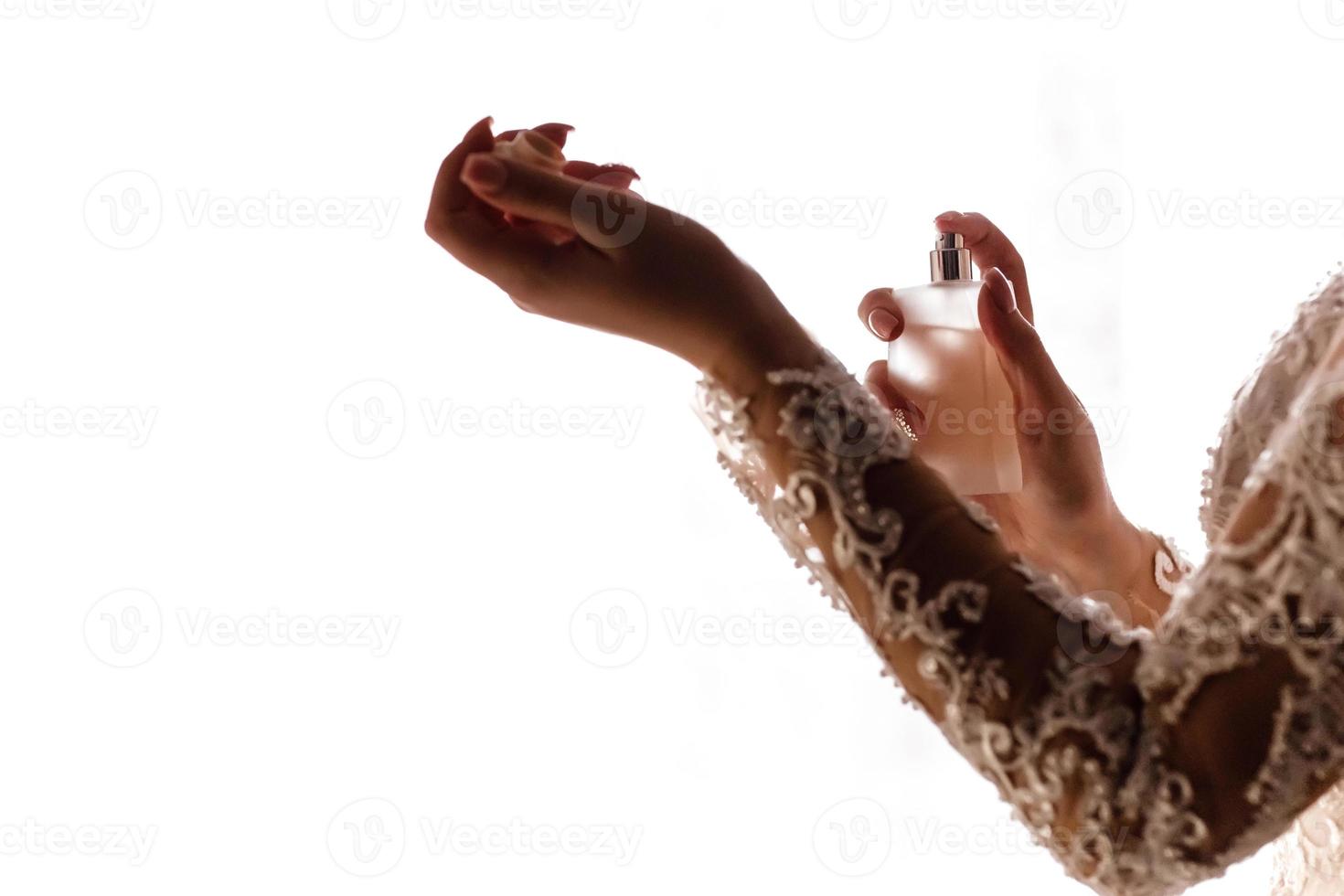 Bride paints perfume on her hands photo