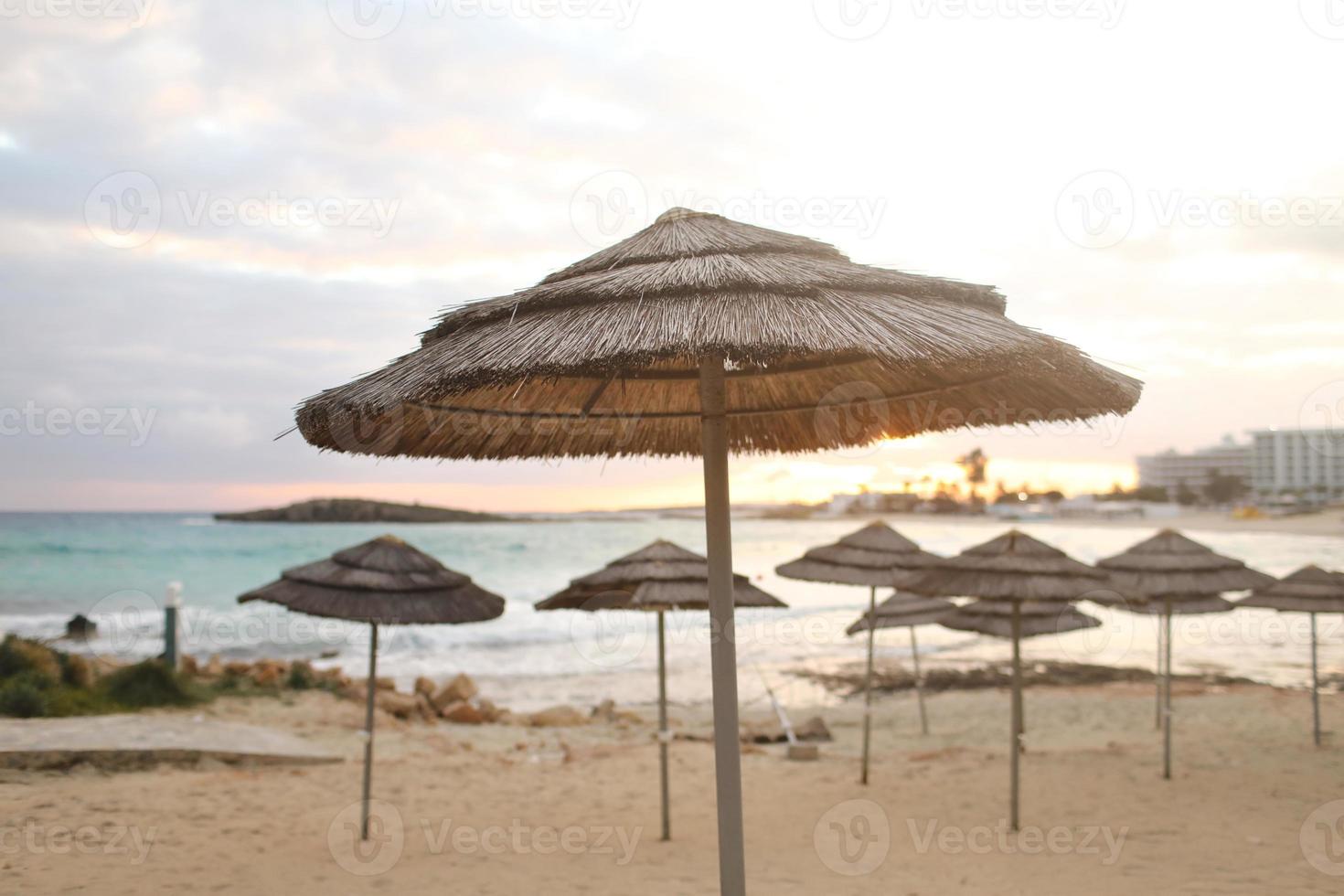 Beautiful straw umbrellas on the beach photo