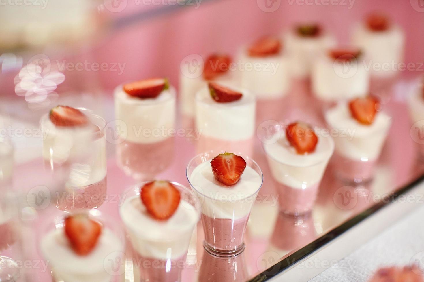 barra de chocolate de boda con postres rosados y blancos foto
