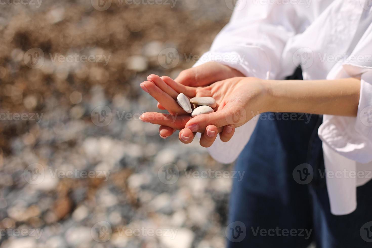 Woman's hands holds pebble stones photo