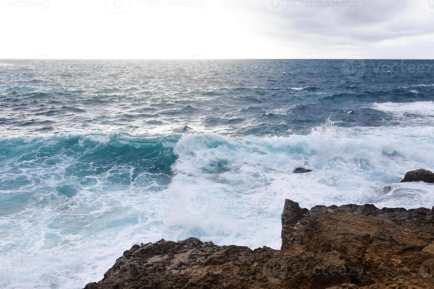 Waves hitting the rocky cliffs on the beach located in Cyprus photo