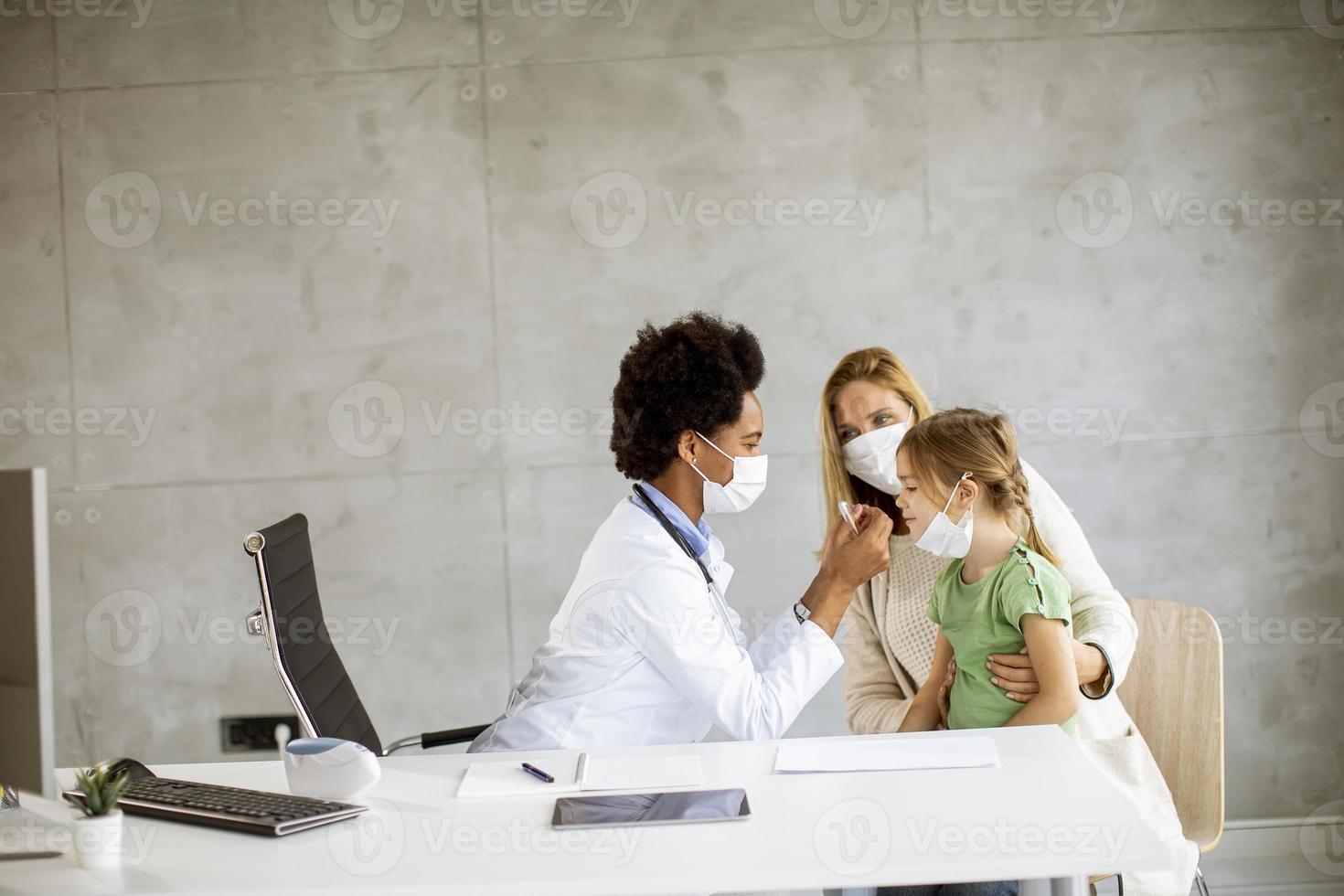 doctor revisando la temperatura del niño foto