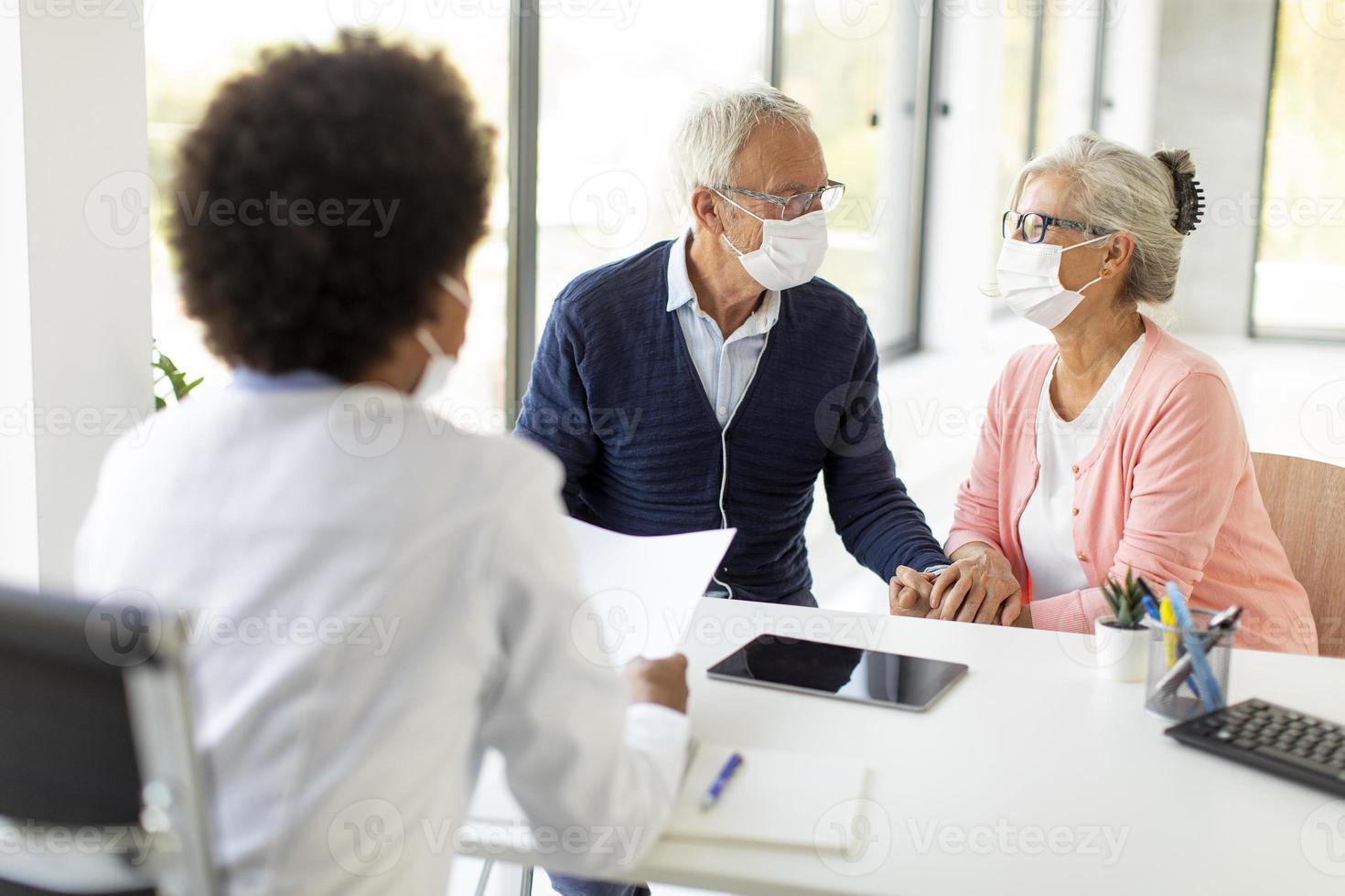 Doctor discussing care with mature couple photo