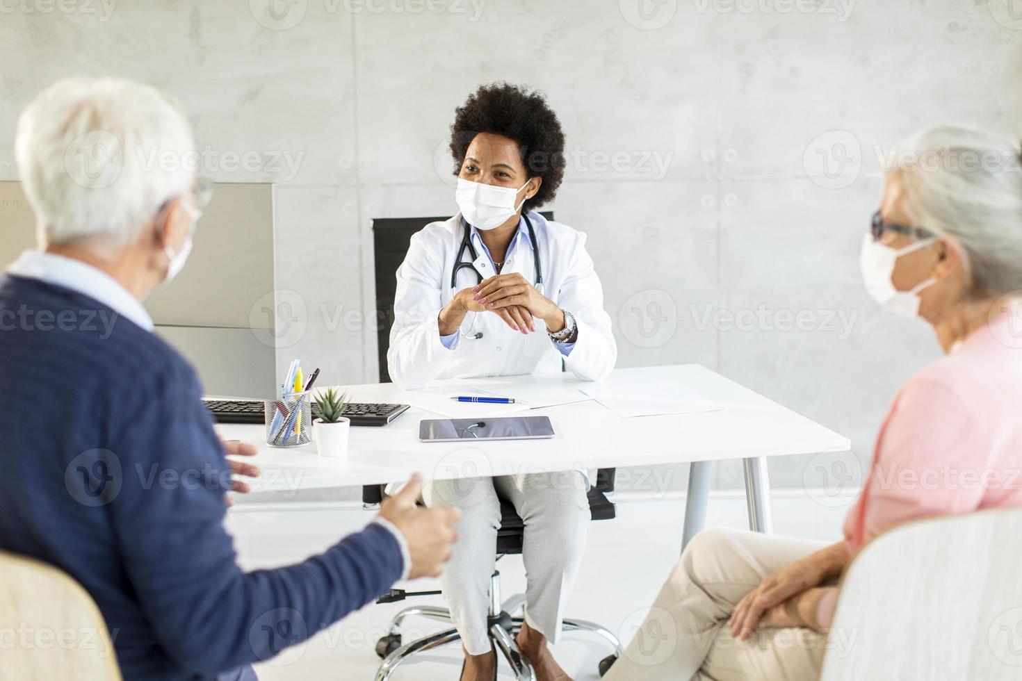 Masked mature couple at doctor's office photo