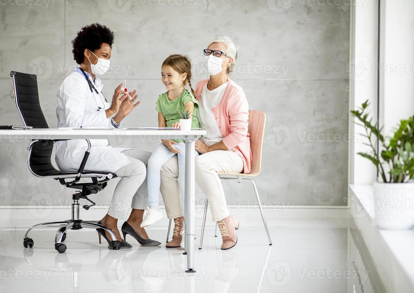 doctor examinando niña con abuela foto