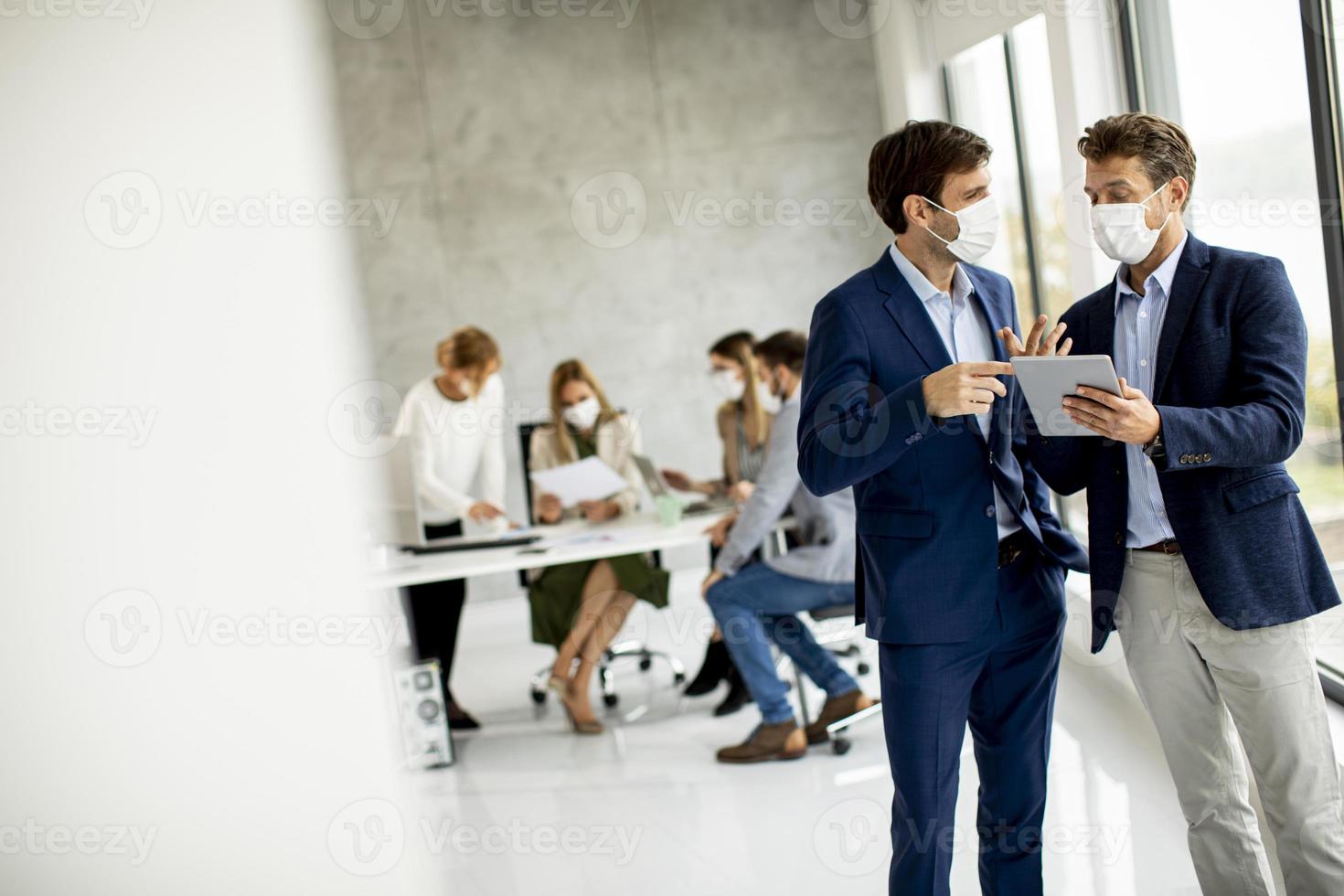Masked businessmen in office photo