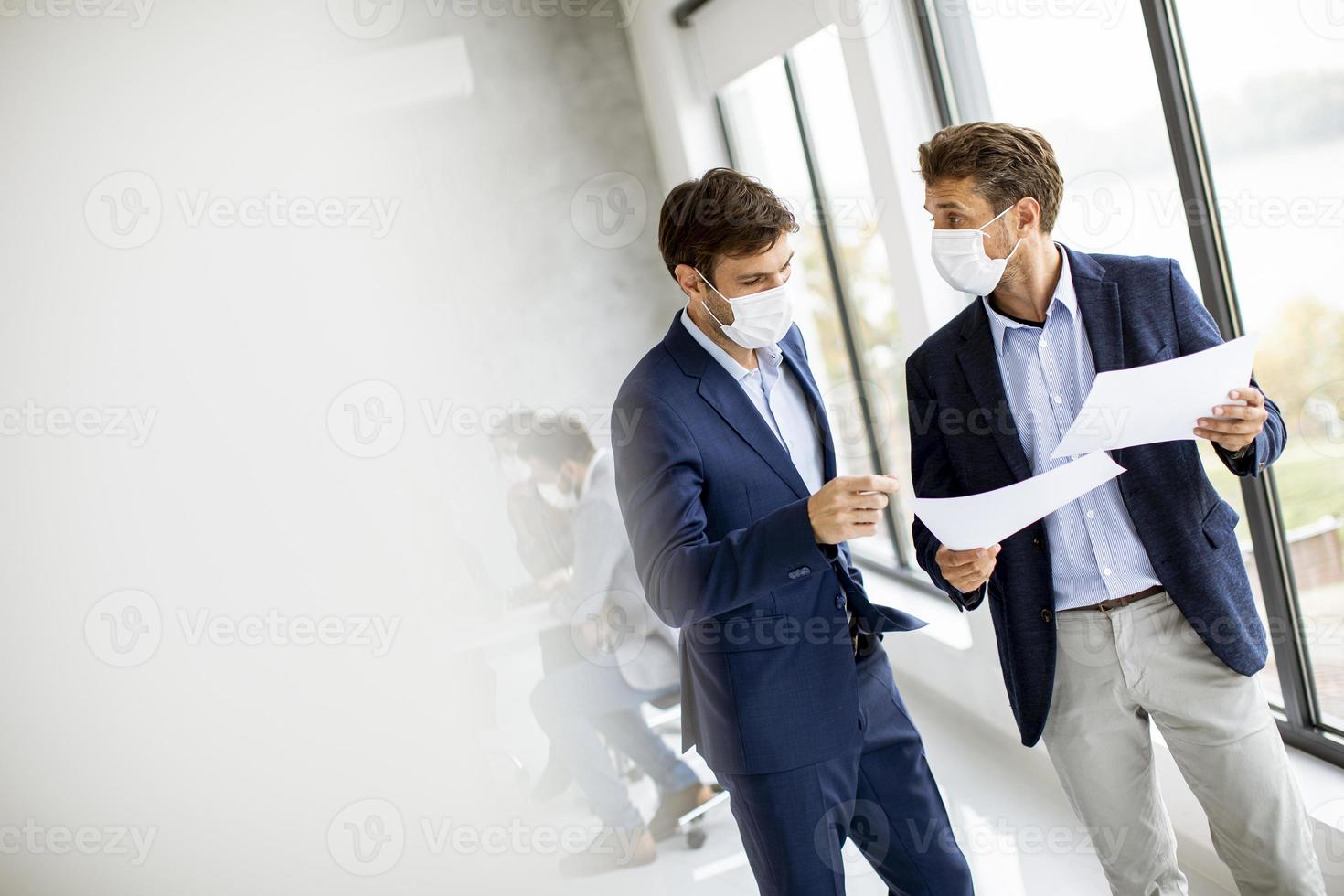 Two men meeting in masks with copy space photo
