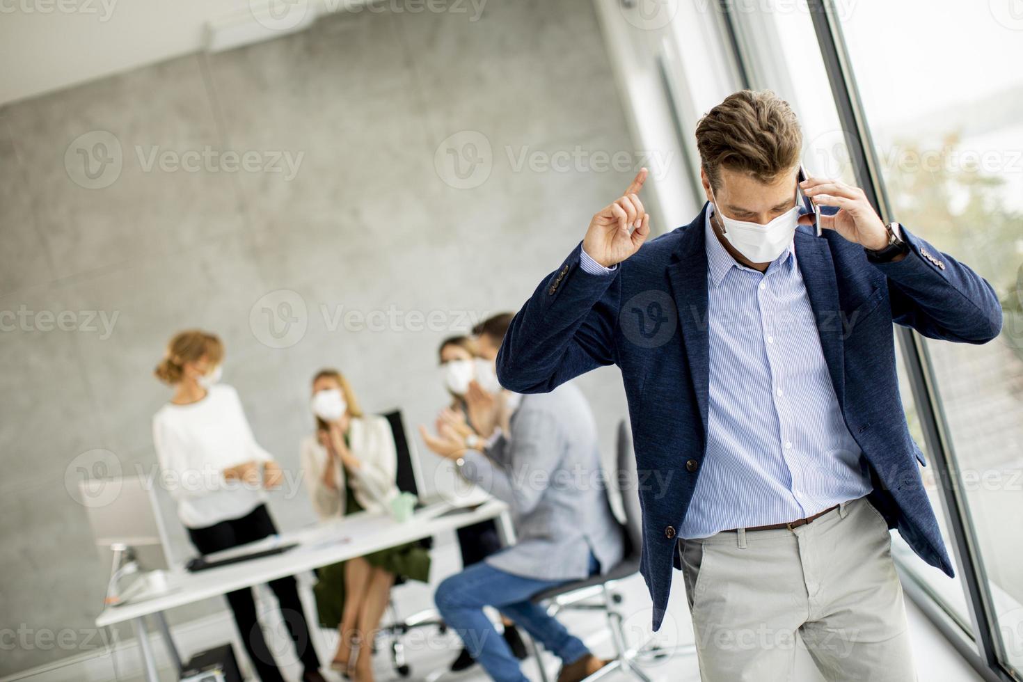 hombre de negocios enmascarado en el teléfono foto