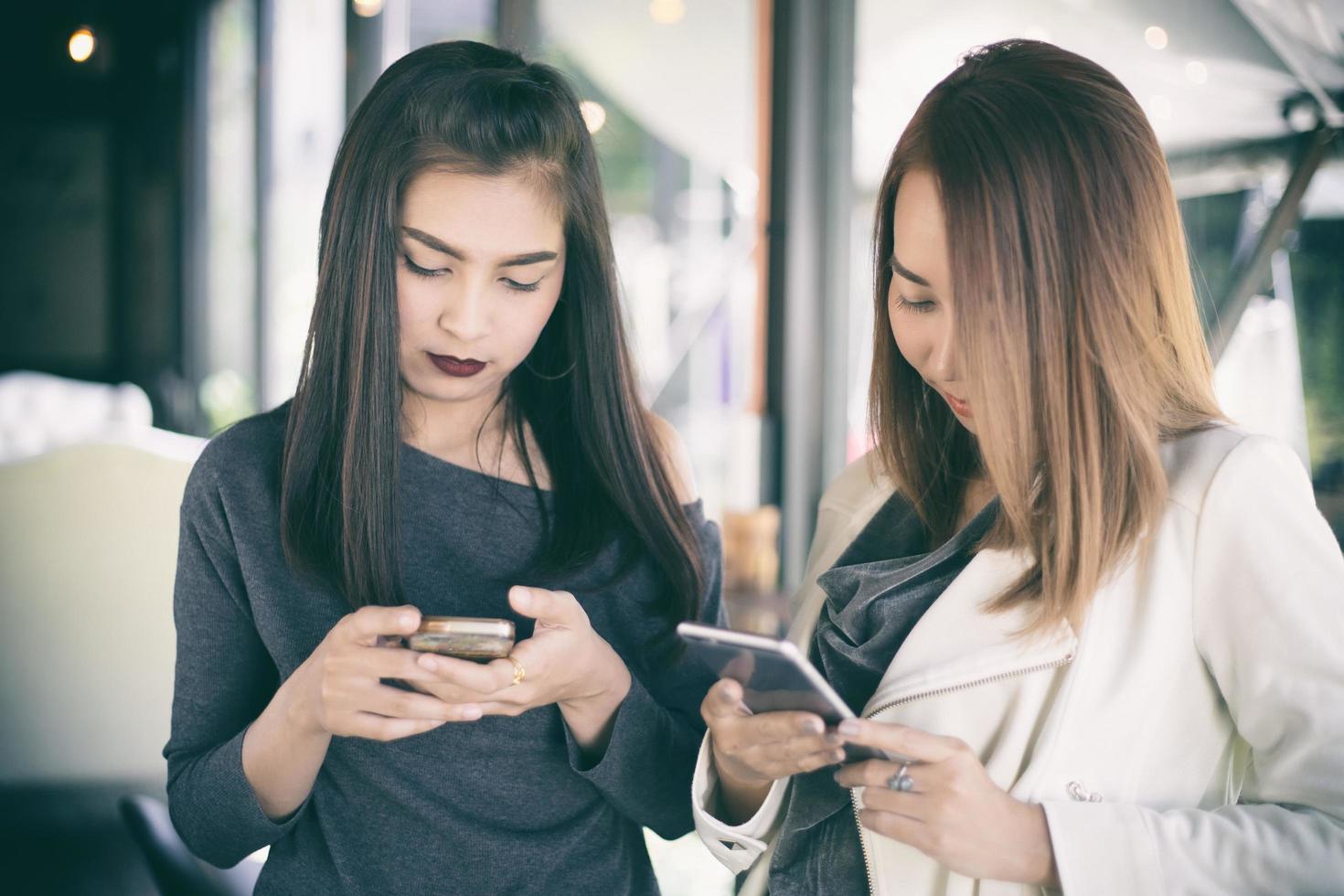 Two women using mobile phones photo