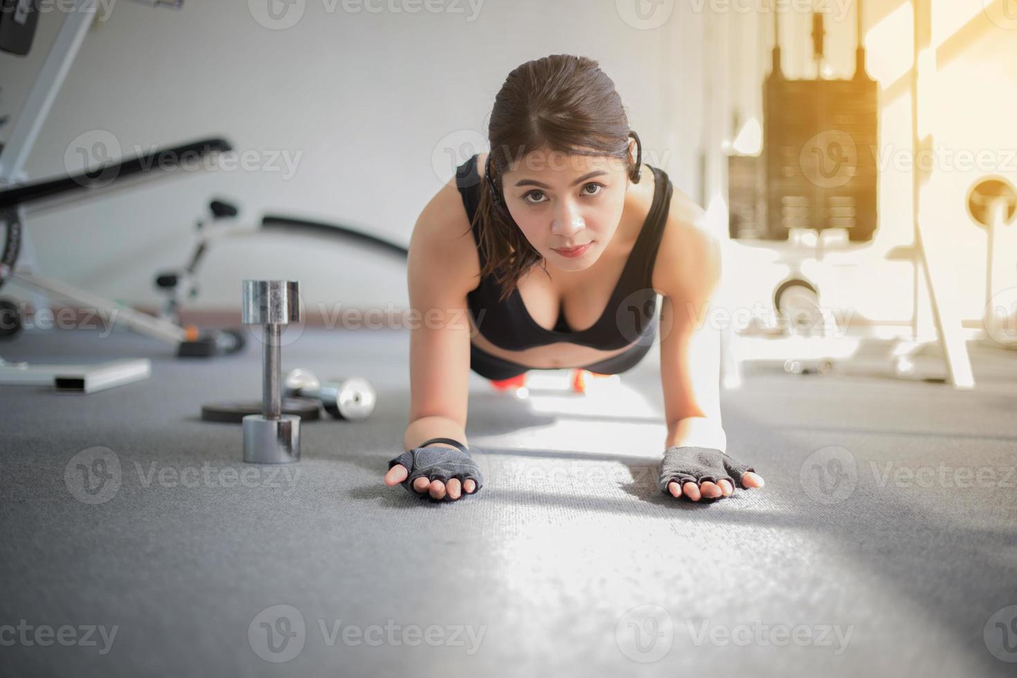 mujer, en, tabla, pose, en, el, gimnasio foto