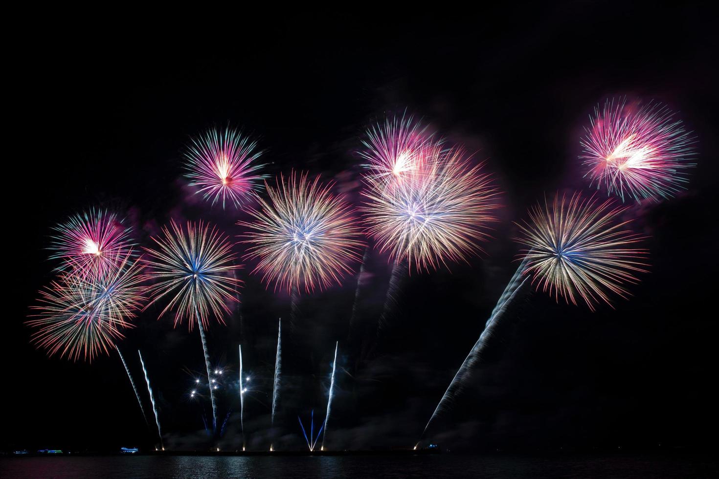 festivo hermoso colorido espectáculo de fuegos artificiales en la playa del mar increíble fiesta de fuegos artificiales o cualquier evento de celebración en el cielo oscuro foto