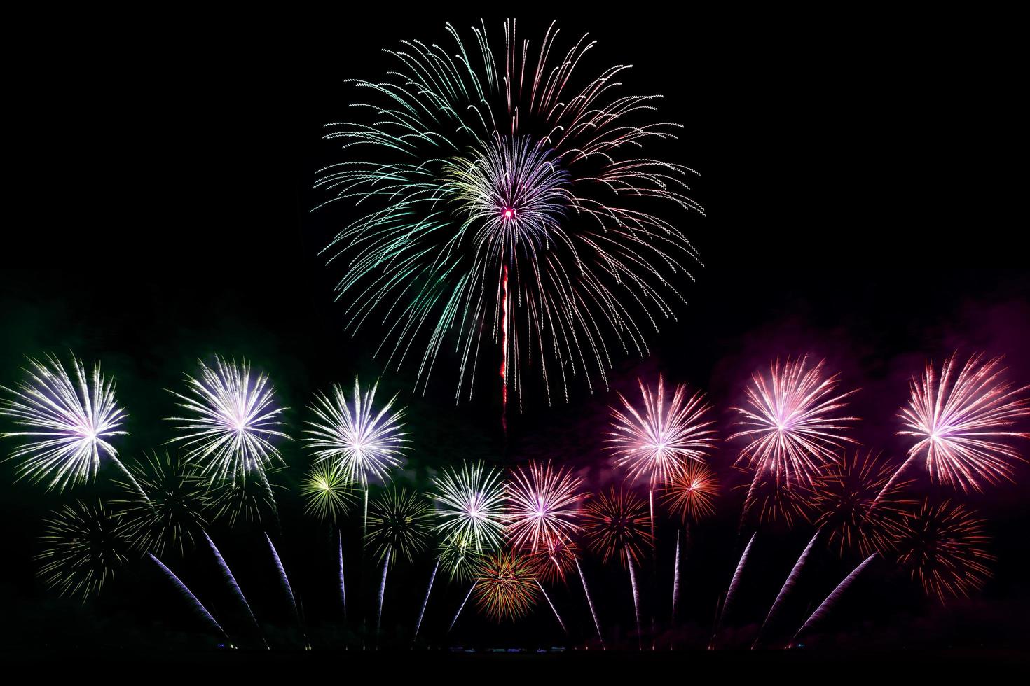 festivo hermoso colorido espectáculo de fuegos artificiales en la playa del mar increíble fiesta de fuegos artificiales o cualquier evento de celebración en el cielo oscuro foto