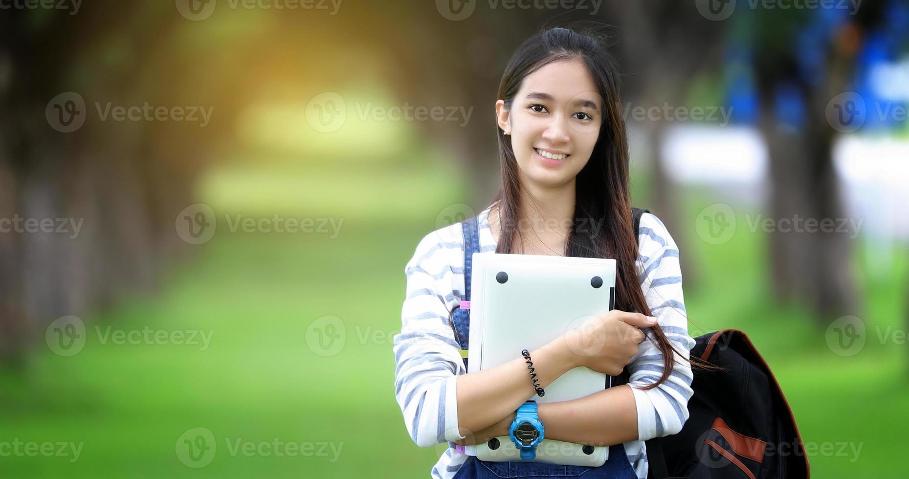 estudiante sonriente sosteniendo laptop foto