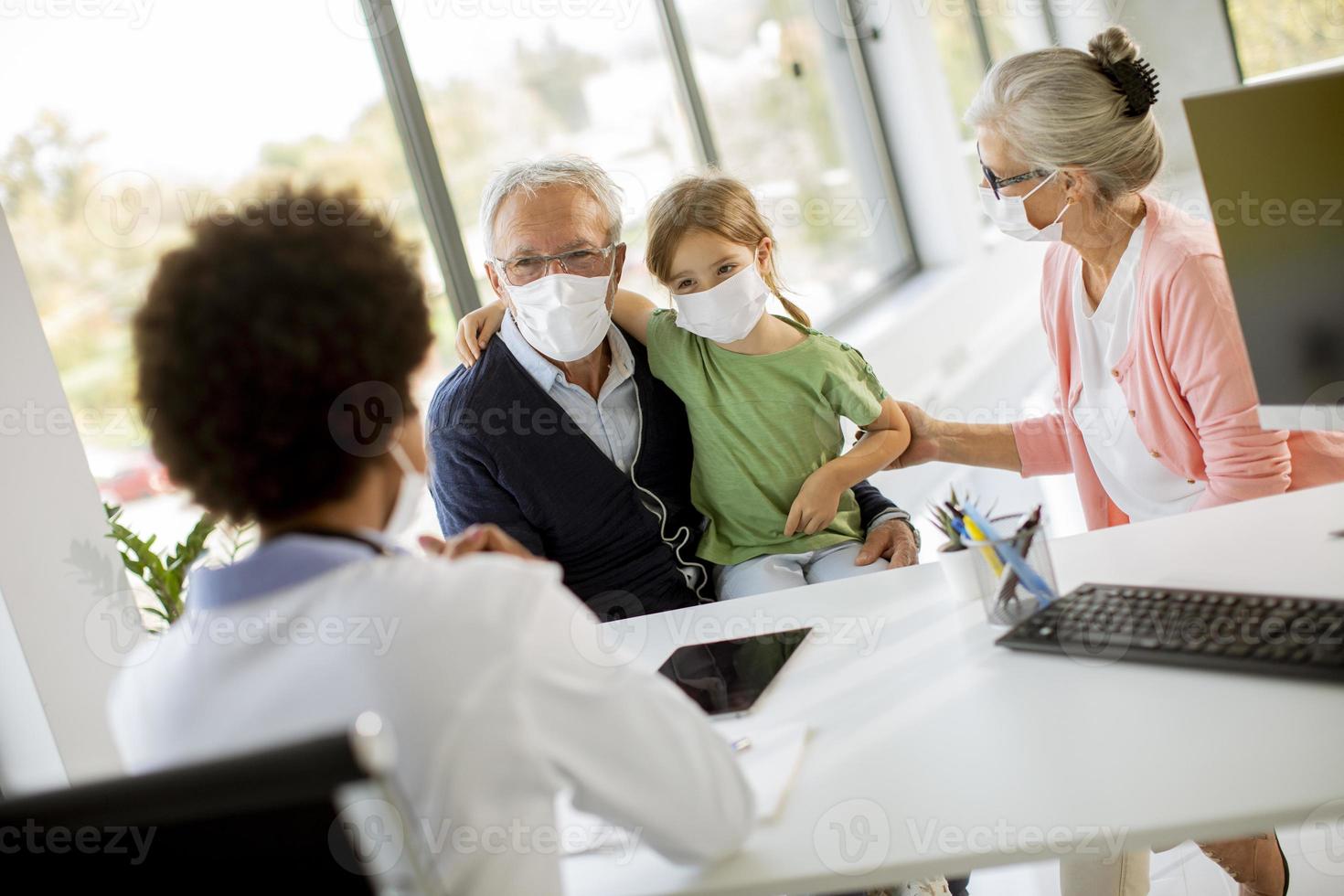 Senior couple with granddaughter at the doctor's photo