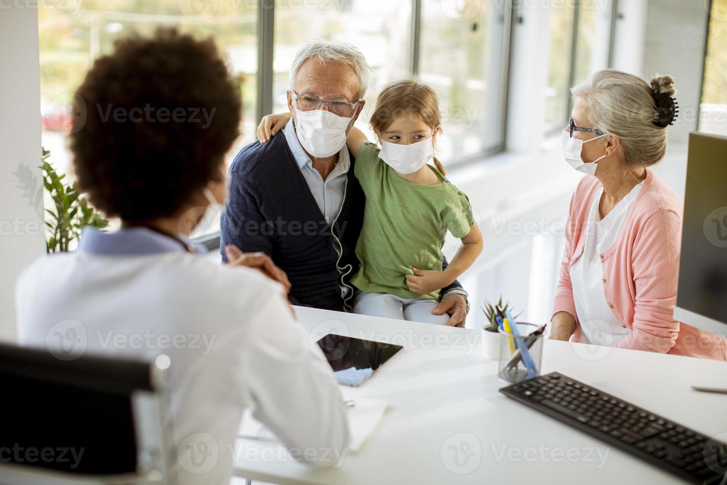 Grandparents taking their granddaughter to the doctor's photo