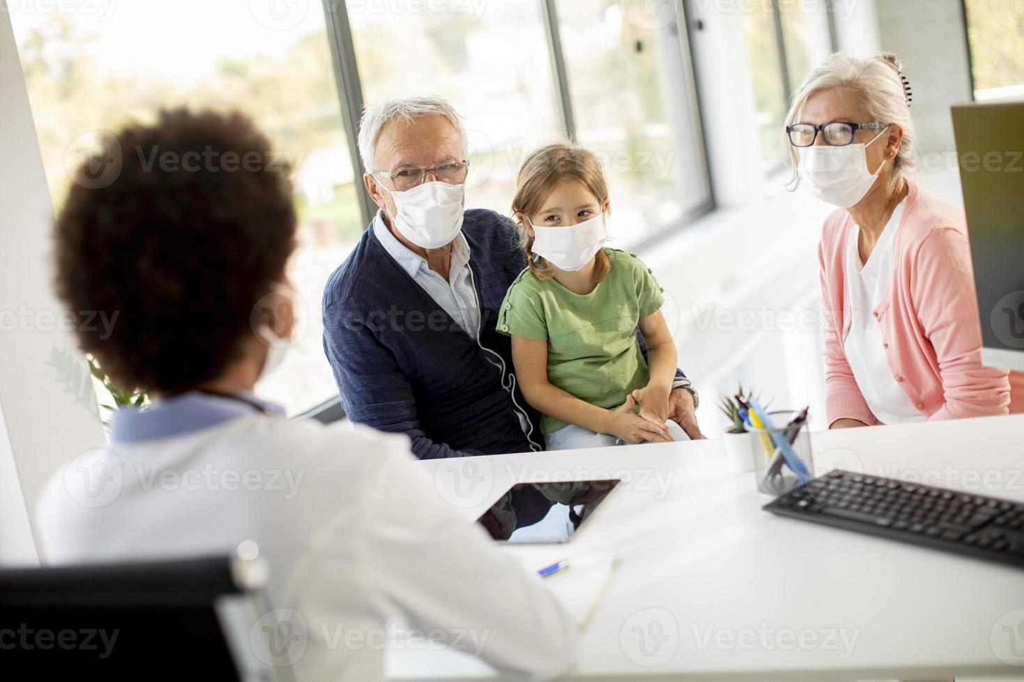 Grandparents with granddaughter at the doctor's office photo