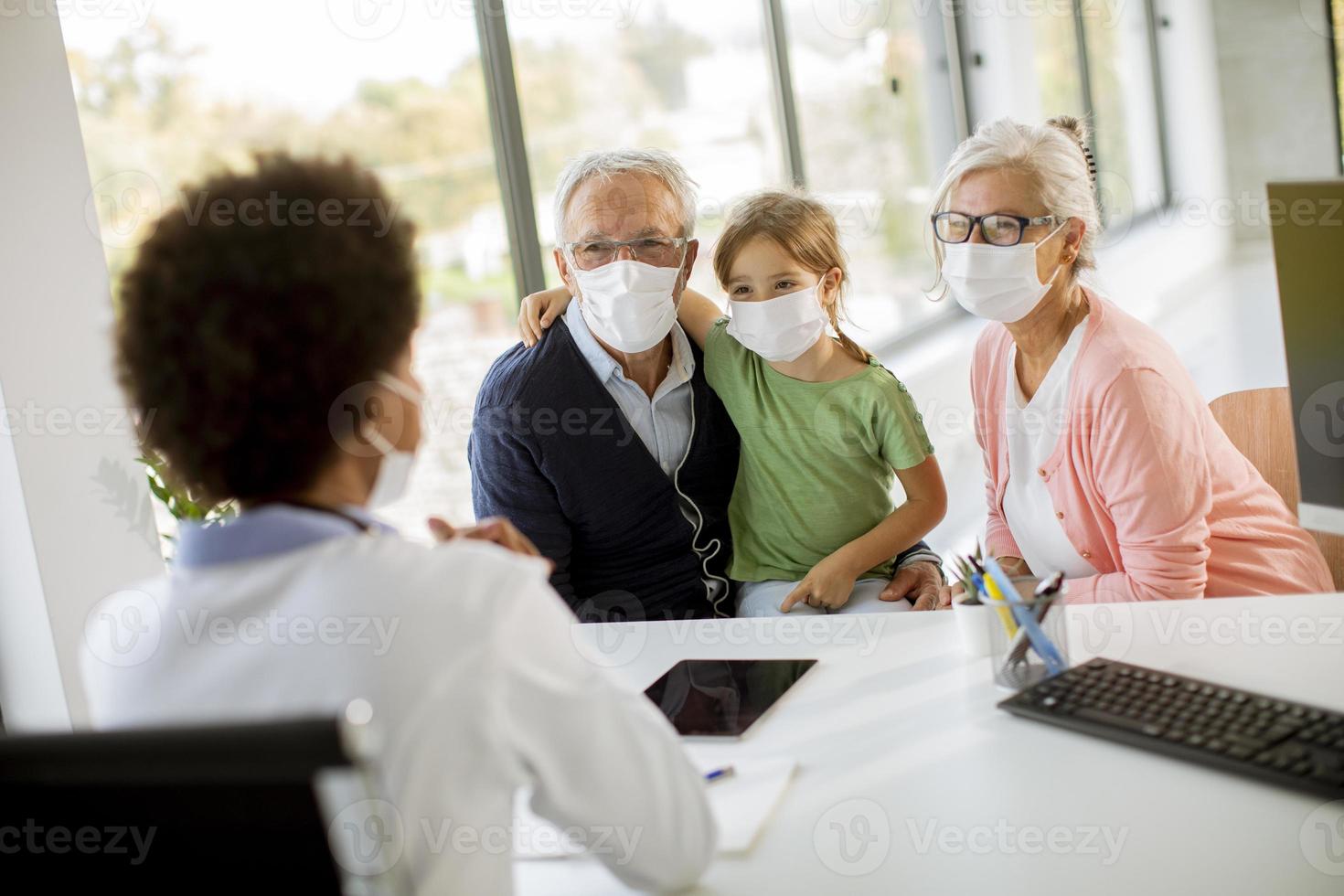 Doctor talking to grandparents and child photo