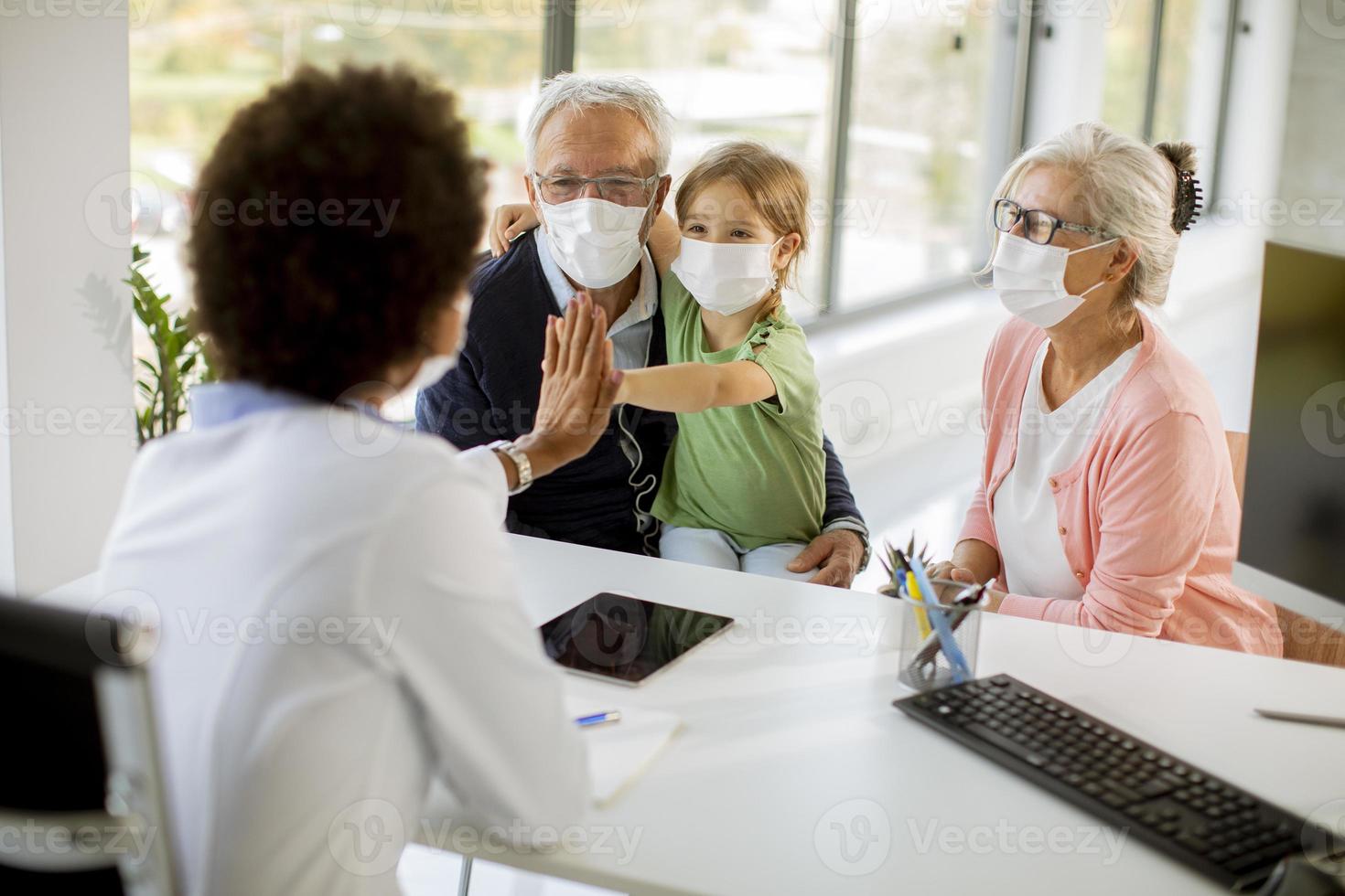 Doctor talking to grandparents and grandchild photo