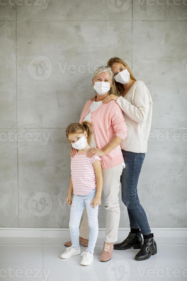 Grandmother, mother and child wearing masks photo