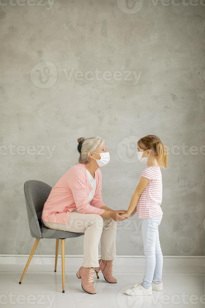 abuela hablando con nieta con máscaras foto