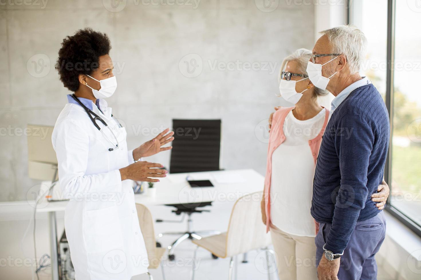 Doctor greeting mature couple photo