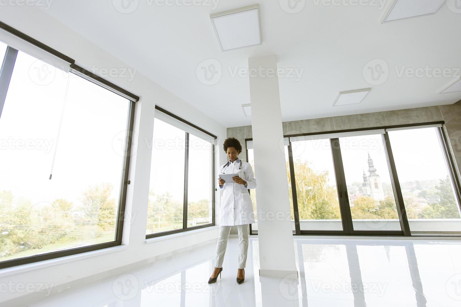 Doctor standing in modern office with tablet photo