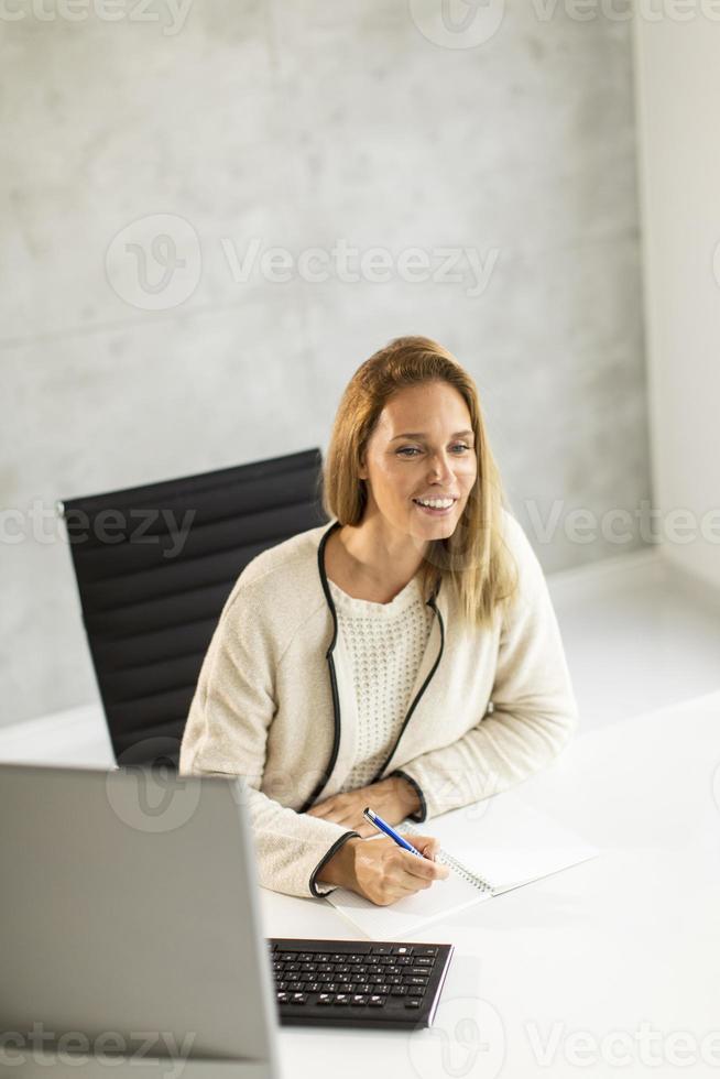 Businesswoman looking up from desk photo