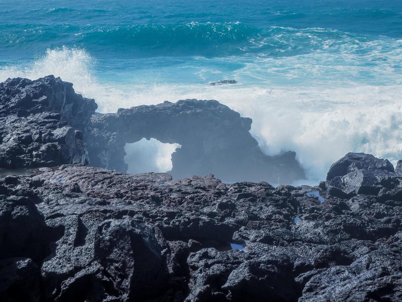 Atlantic waves meeting a rock arch at El Golfo on the volcanic coast of Lanzarote Canary Islands photo