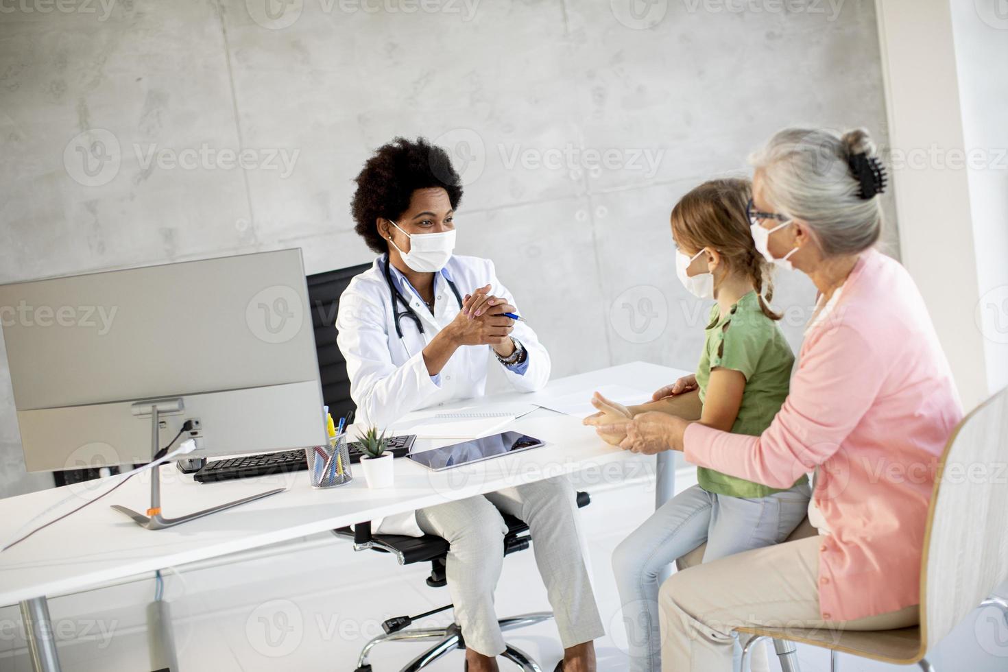 abuela con nieta hablando con el doctor con máscaras foto