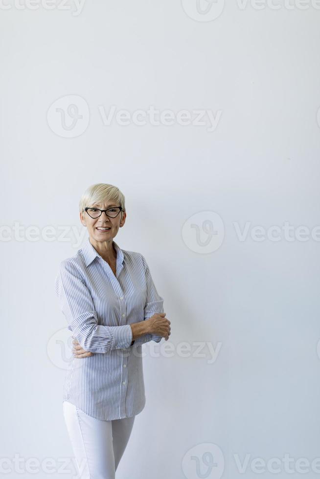 Vertical view of mature businesswoman with arms crossed with copy space photo