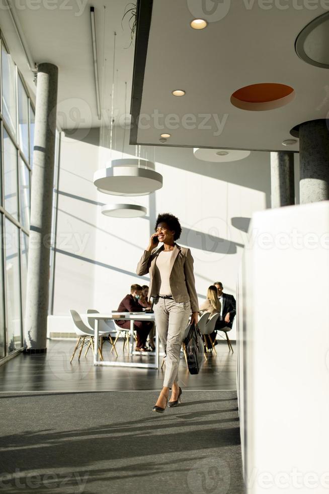 Businesswoman walking and talking on phone in an airport photo