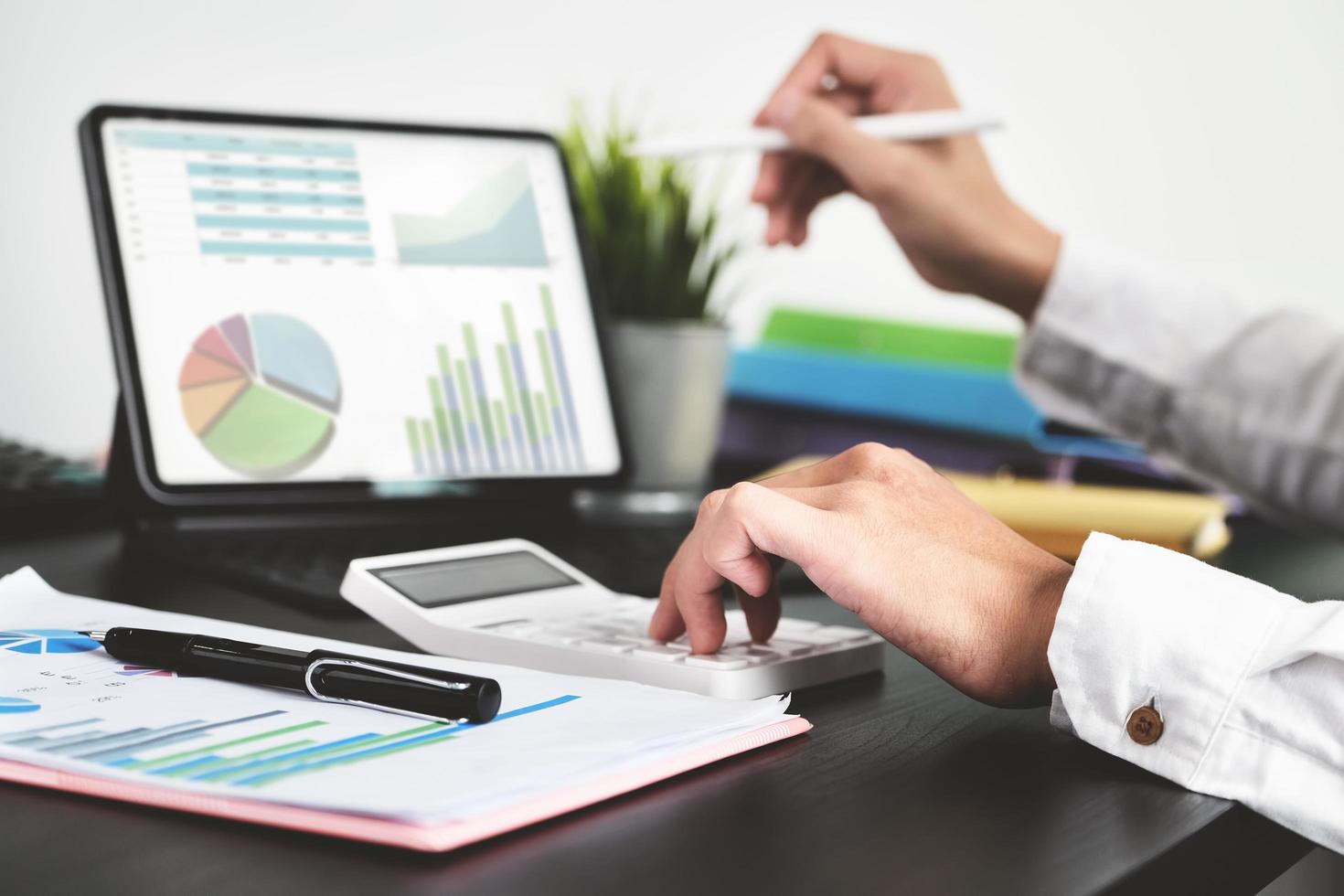 The young businessman using calculators and computers to check financial statements at home instead of working in the office photo