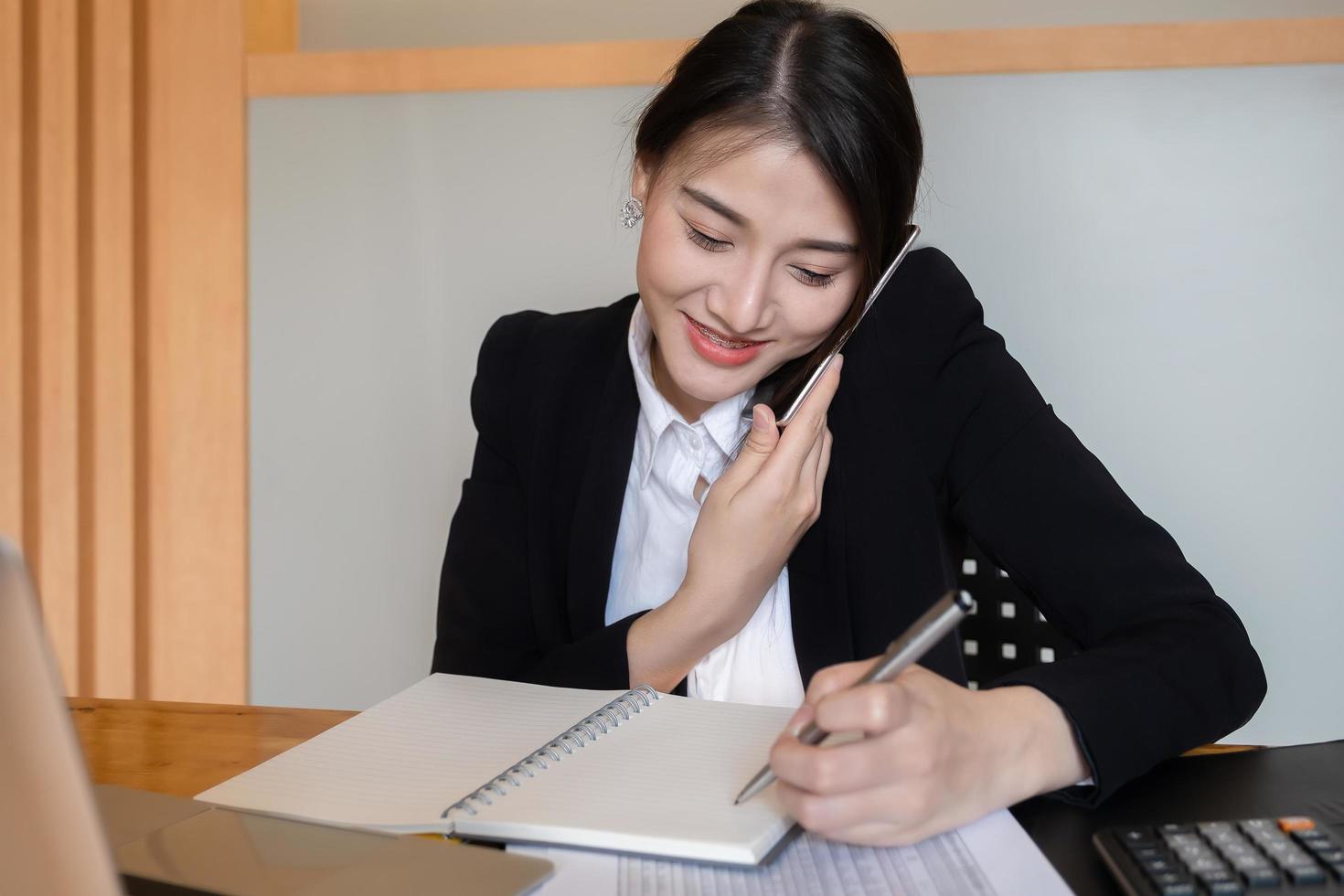 Businesswoman or accountants are calling and working at the office to verify the accuracy of the account using a calculator and laptop computer photo