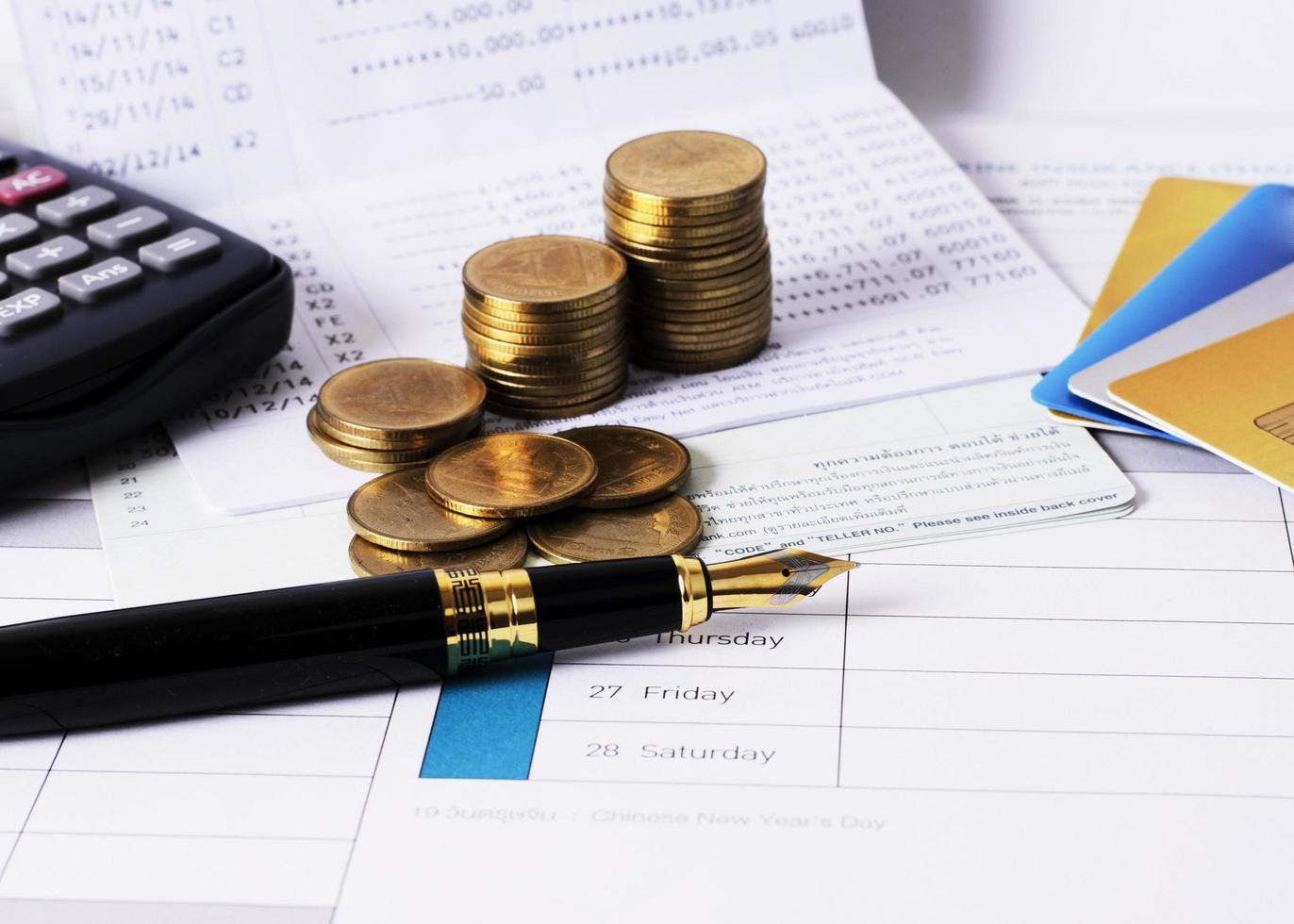 Close up of fountain pen with coins stack and credit card photo