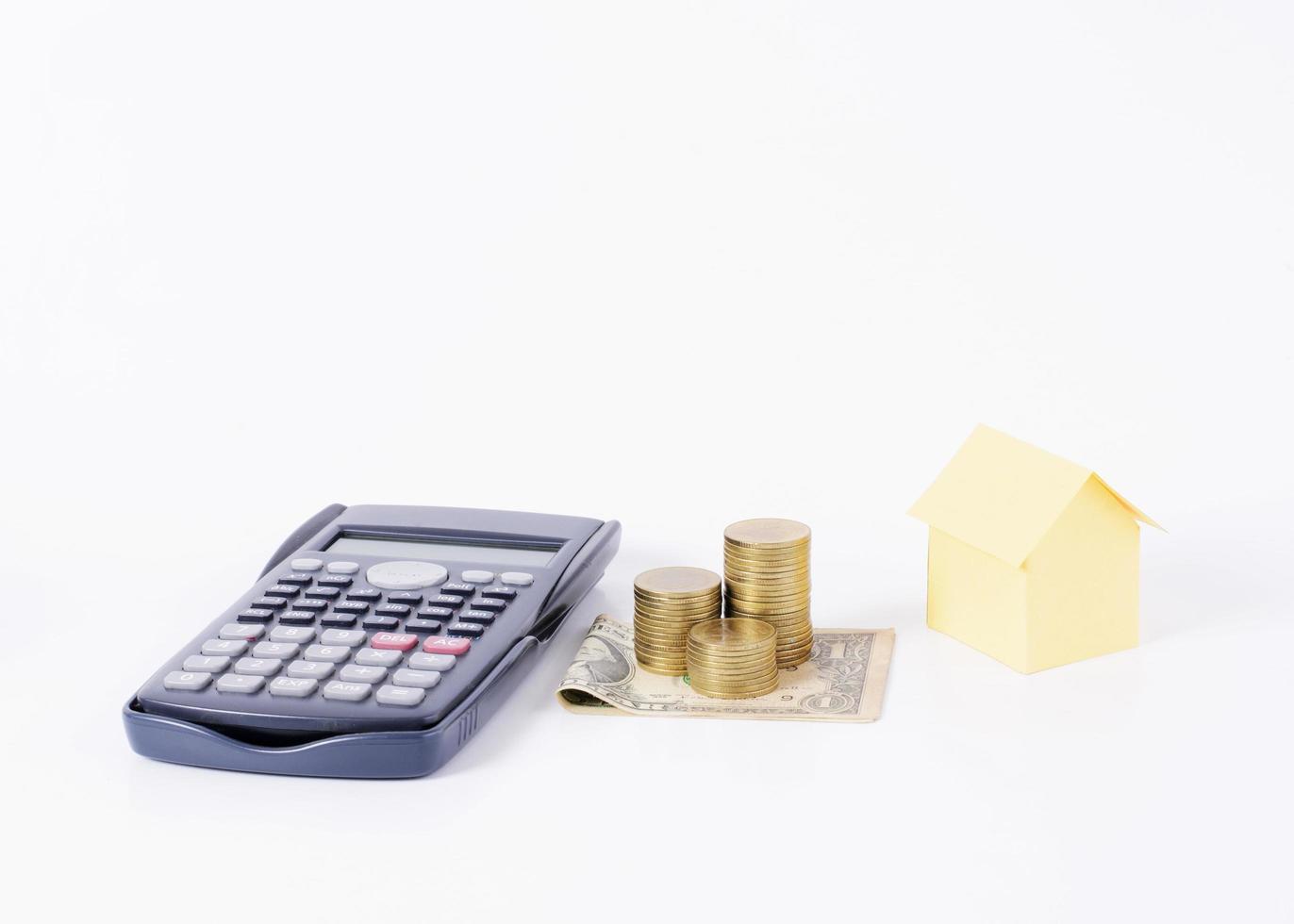 Calculator and money coins stack with home paper for loans money concept photo