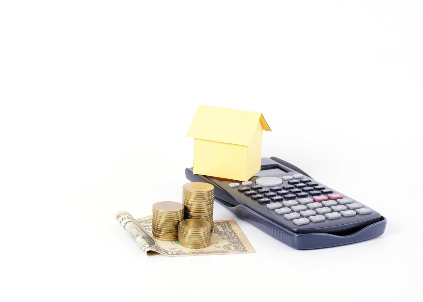 Dollar banknote and coins stack with home paper on calculator for loans concept photo