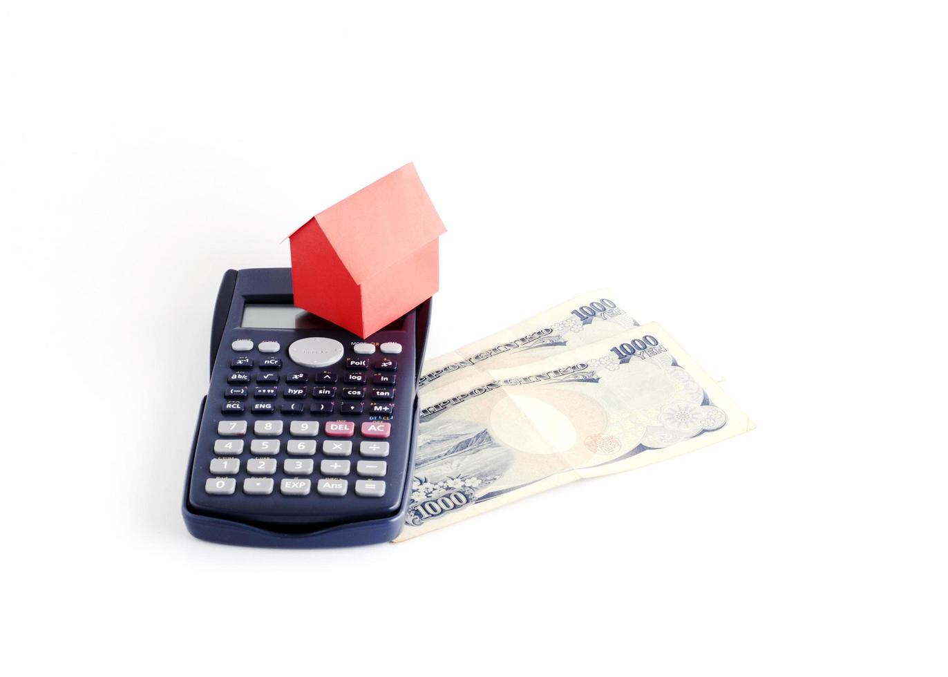 Red house paper and calculator and Japanese banknote on white background photo