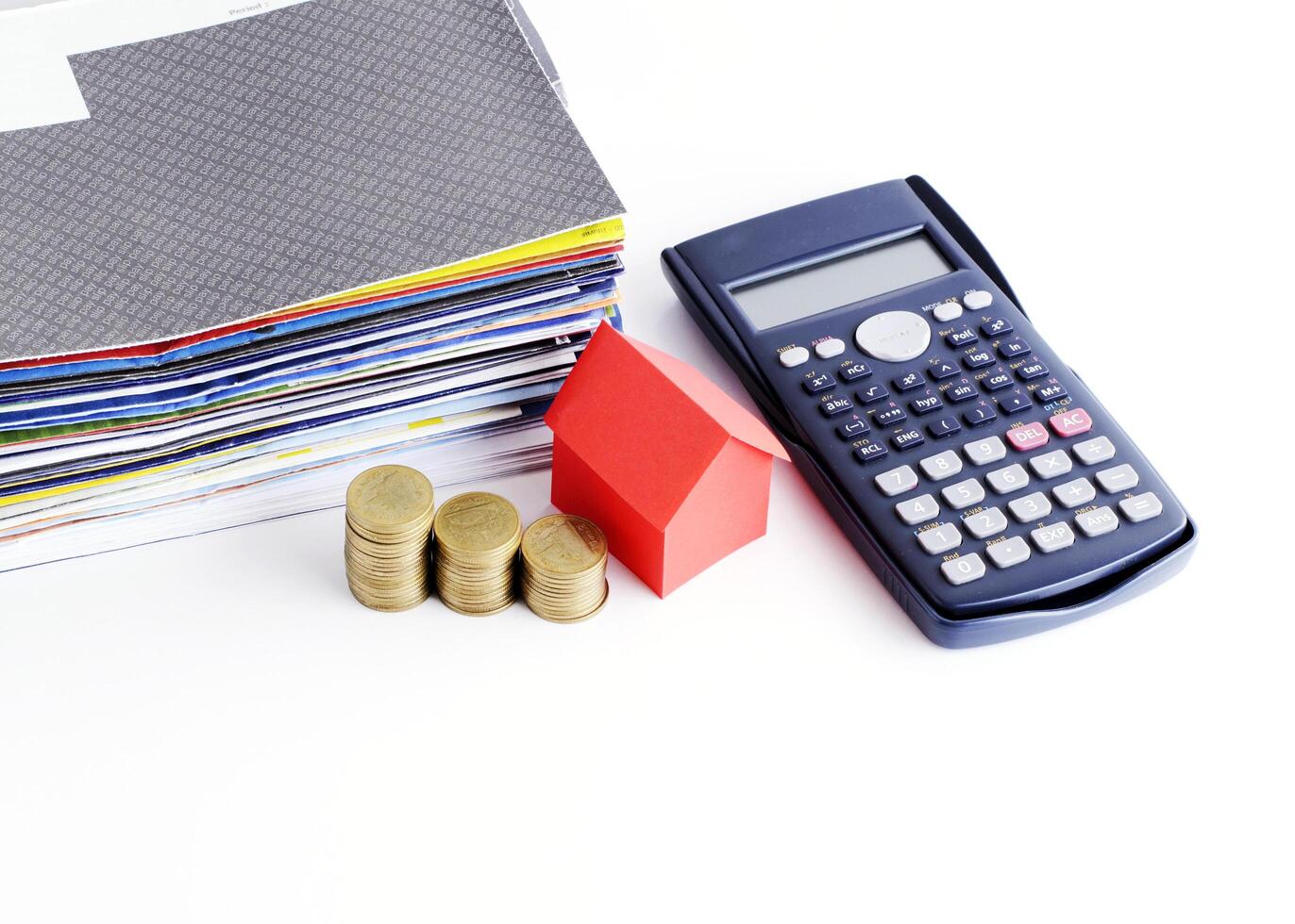 Calculator and red house paper and coins stack and bill payment for loans money concept photo