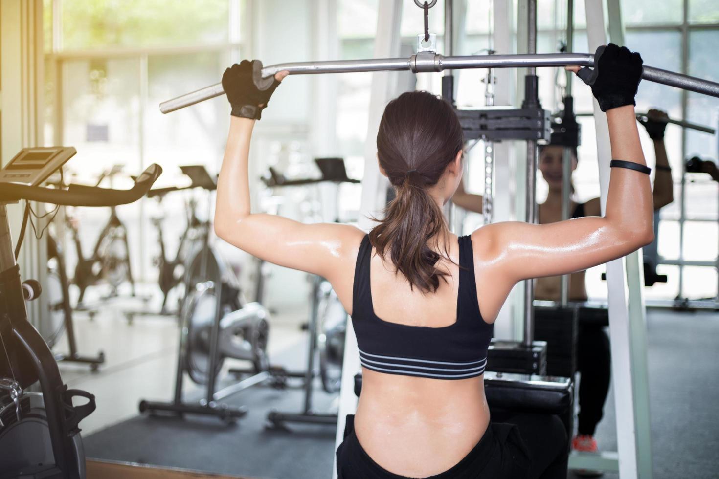 Mujer con máquina de ejercicio en el gimnasio. foto