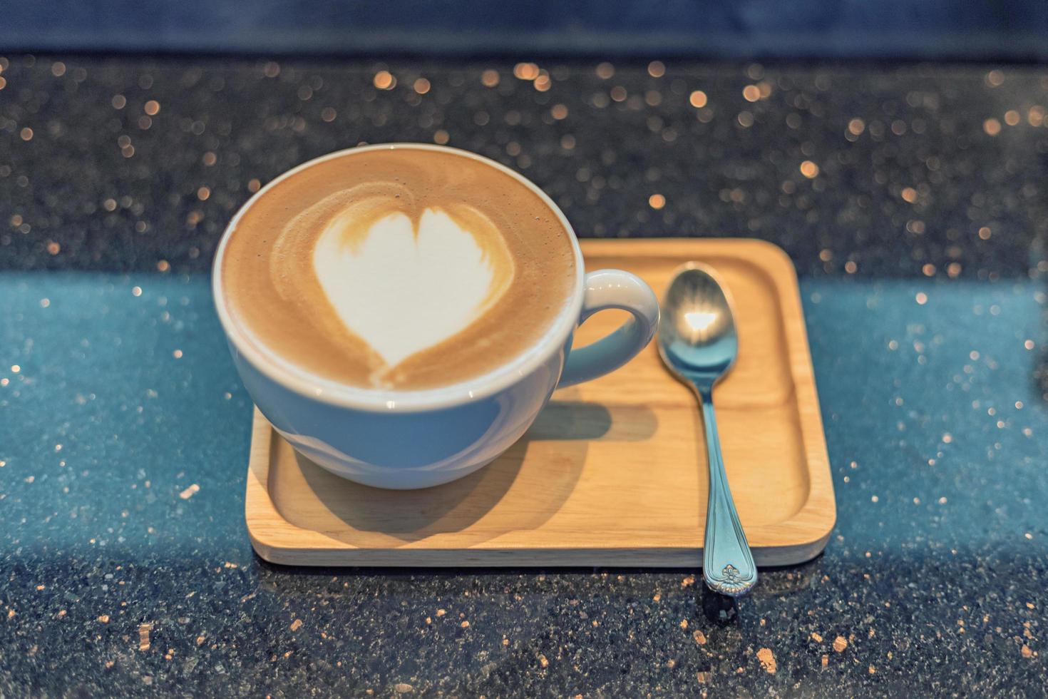 Taza de café capuchino en la mesa de madera foto