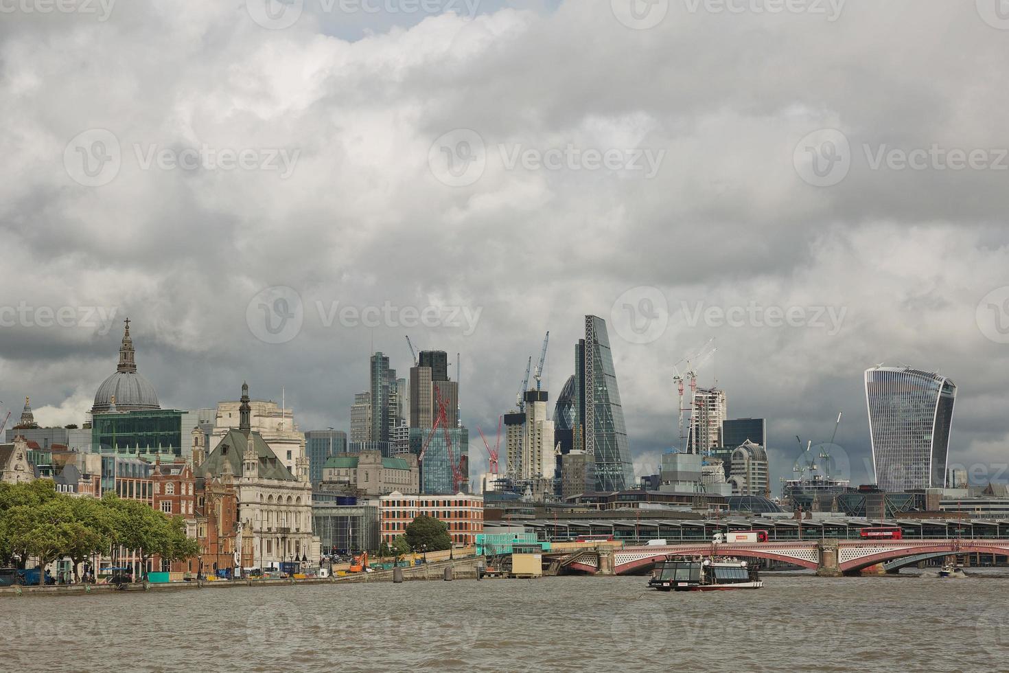 View of architecture of the city of London in UK alongside the riverbank of River Thames photo