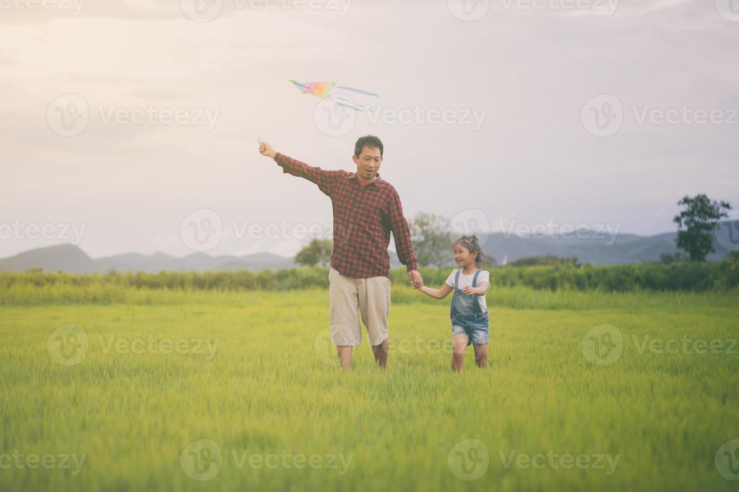 niño y padre jugando con cometas en el parque foto